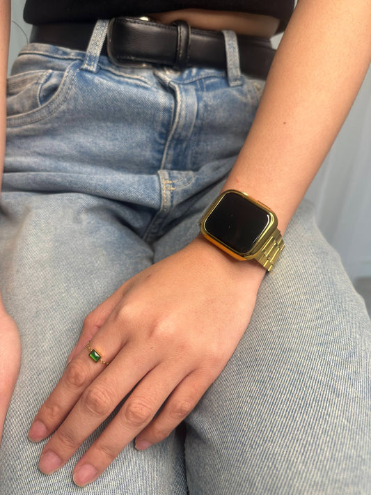 Photo of a woman's hand wearing the adjustable thin gold ring with a gold sphere adjuster featuring rectangular green gem